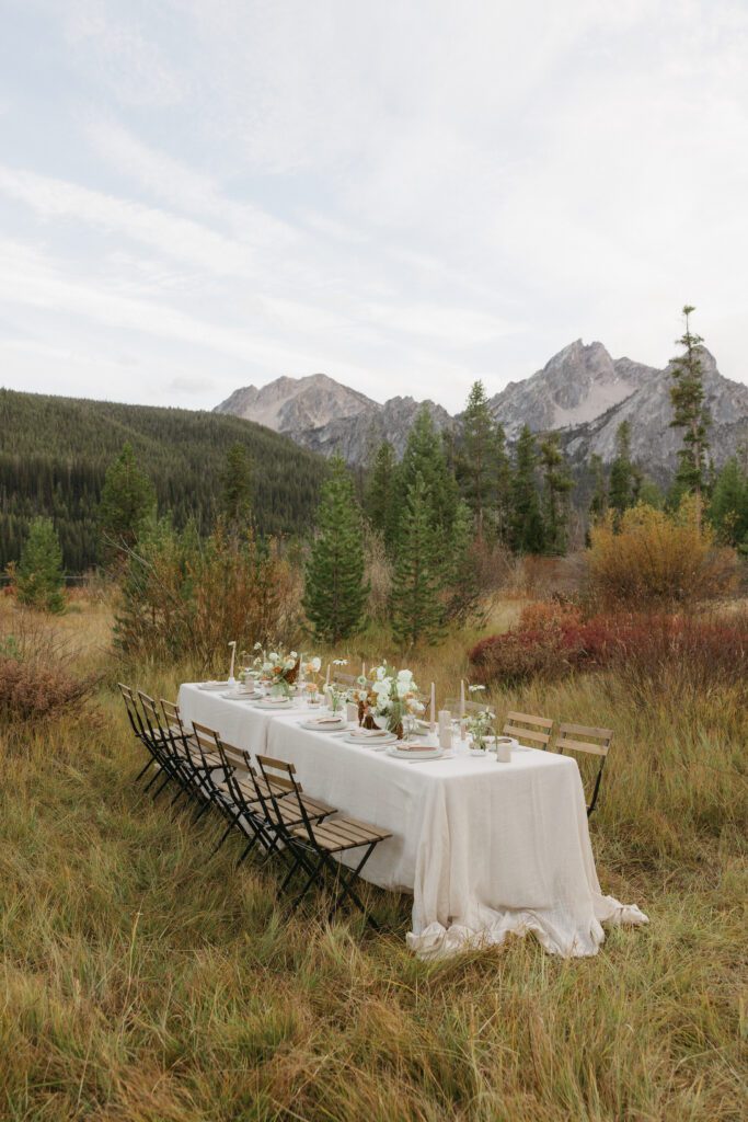 Elegant tablescape set against the backdrop of the Sawtooth Mountains in Idaho, showcasing a serene and picturesque dining setting