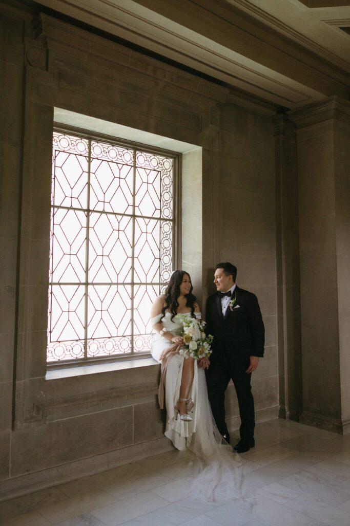 bride sitting on window sill 