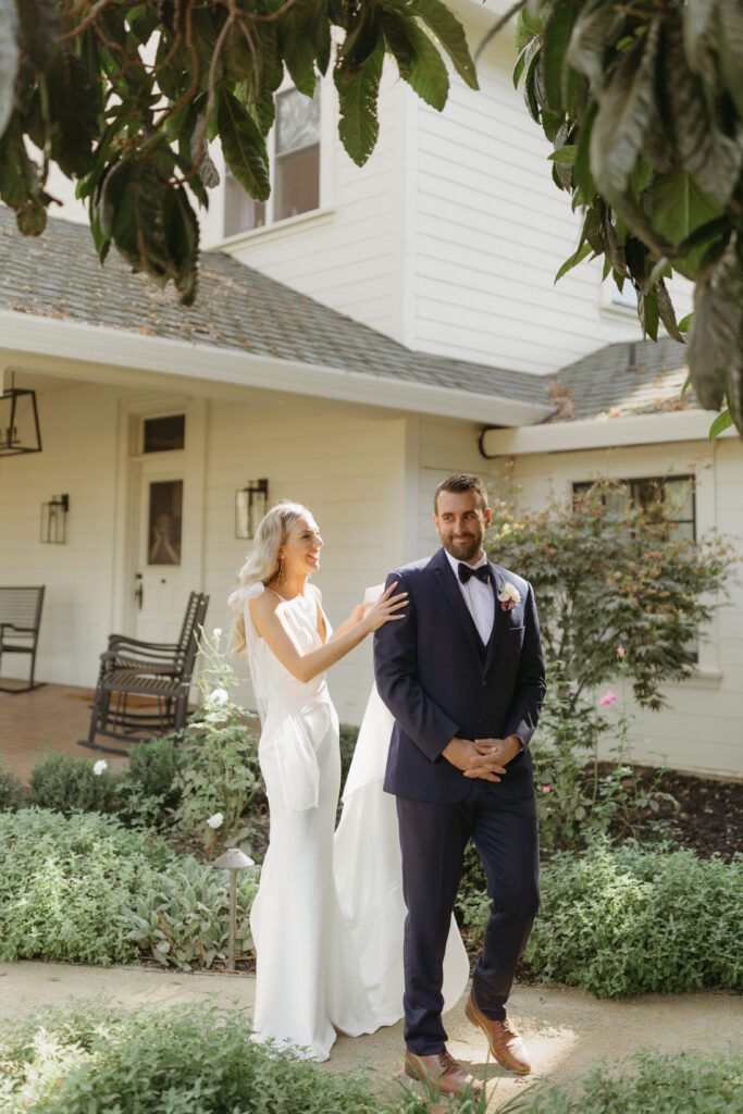 Bride and groom sharing a tender moment during their first look, with the groom's reaction showing joy and admiration