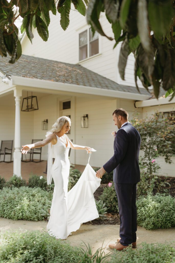 Bride and groom embracing during their first look, surrounded by natural scenery and soft sunlight