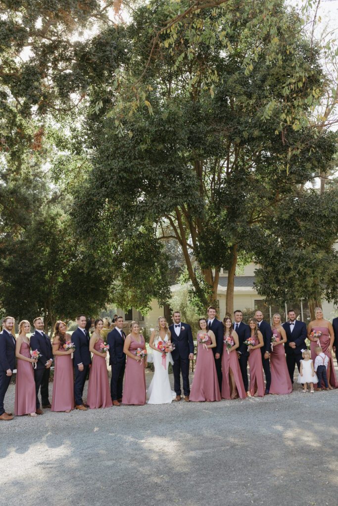 Full bridal party posing together, showcasing their attire and joyous expressions