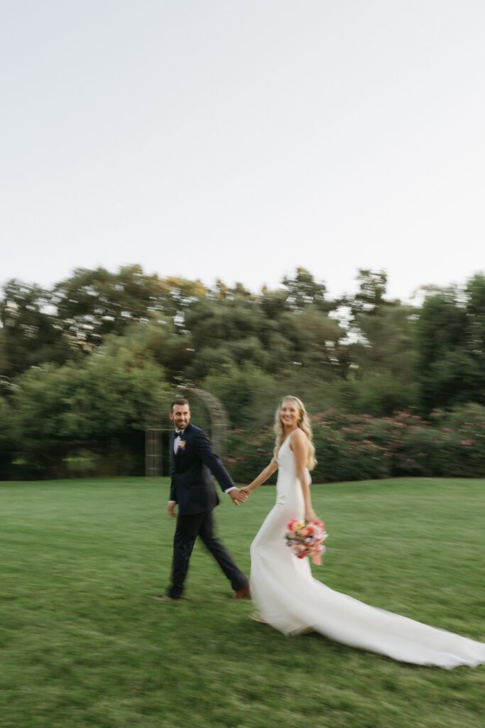 Bride and groom walking hand in hand for their golden hour photos