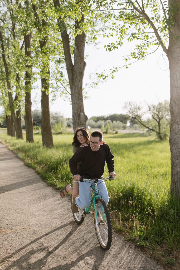 Engaged couple sharing a joyful moment on their vintage bicycle in Boise, Idaho.