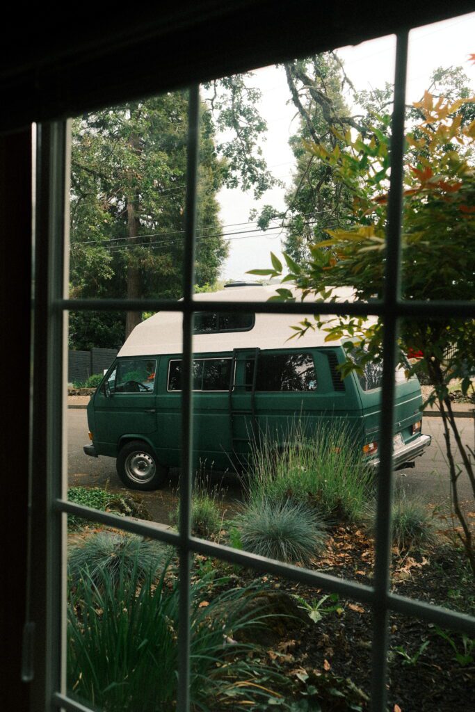 View of travel van through cottage window at private elopement in Oregon.