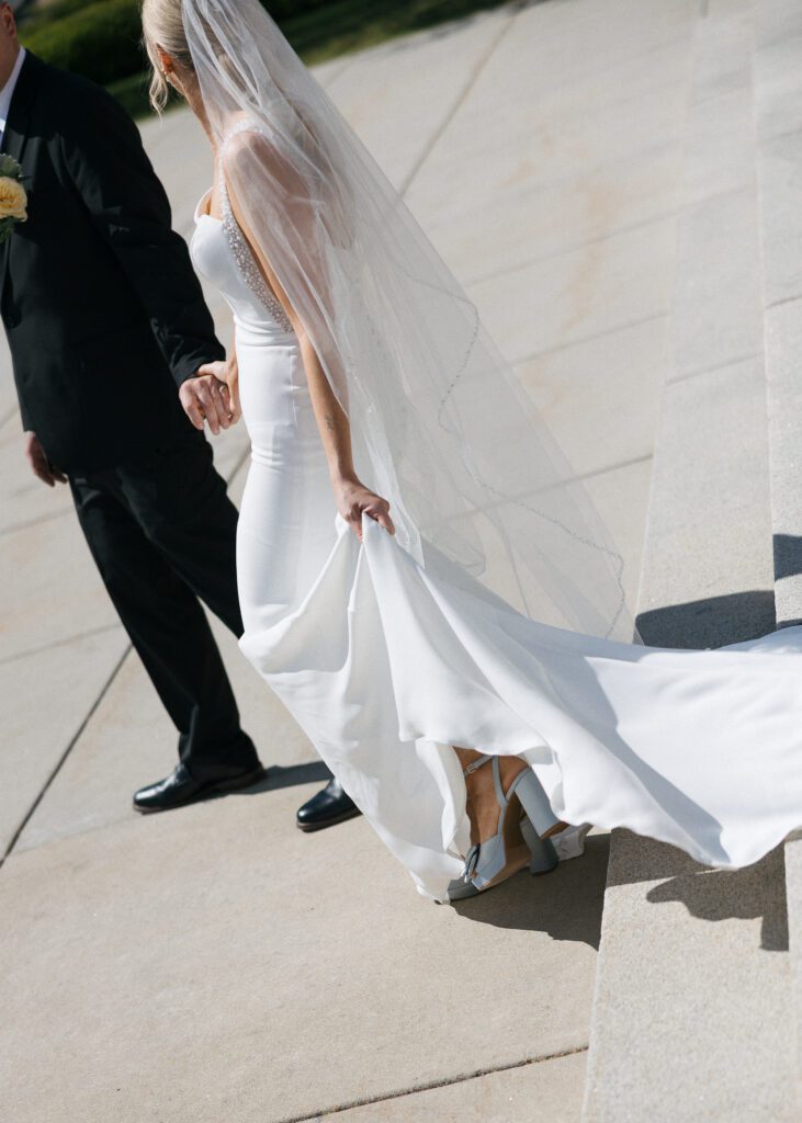Bride and groom walking together during portraits outside Idaho State Capitol.