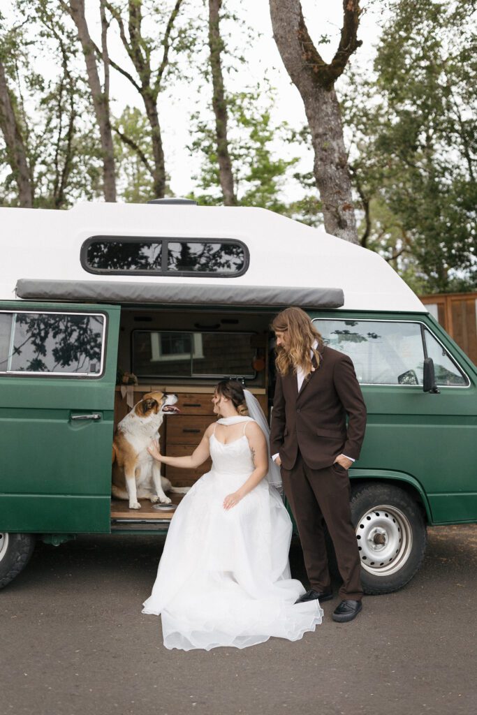 Couple pose with dog in travel van for elopement photos in Oregon.