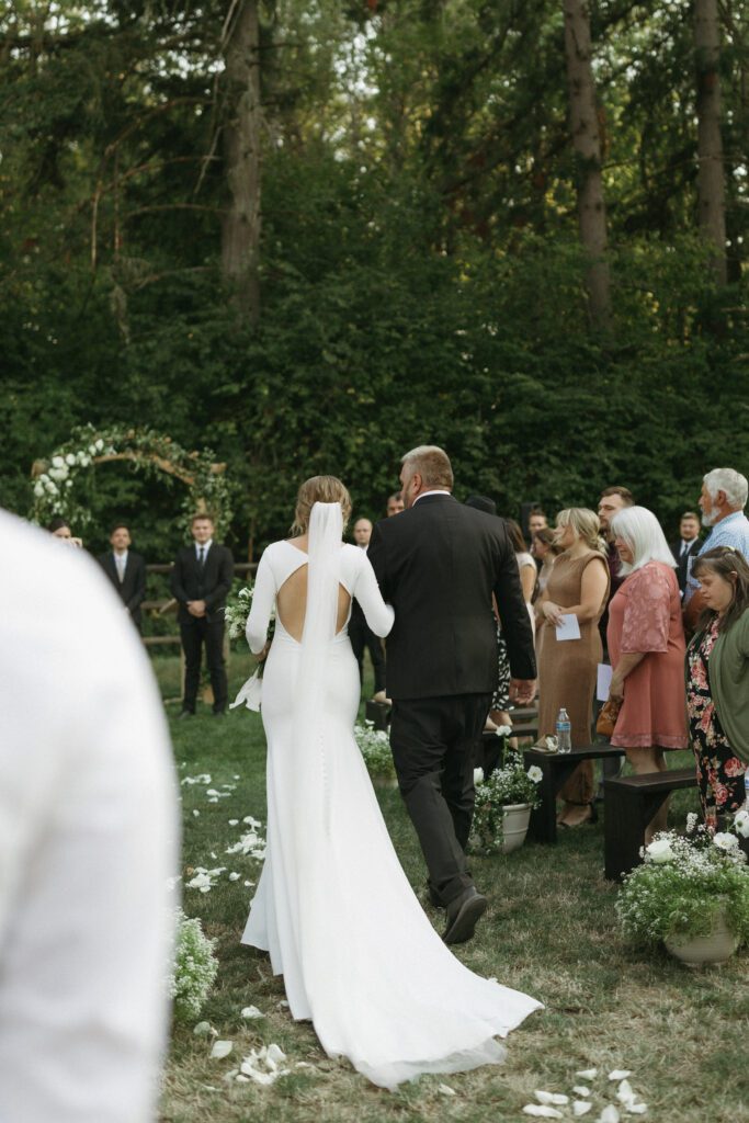 Father-of-bride walks her down the isle during wedding ceremony in Vancouver, Washington.