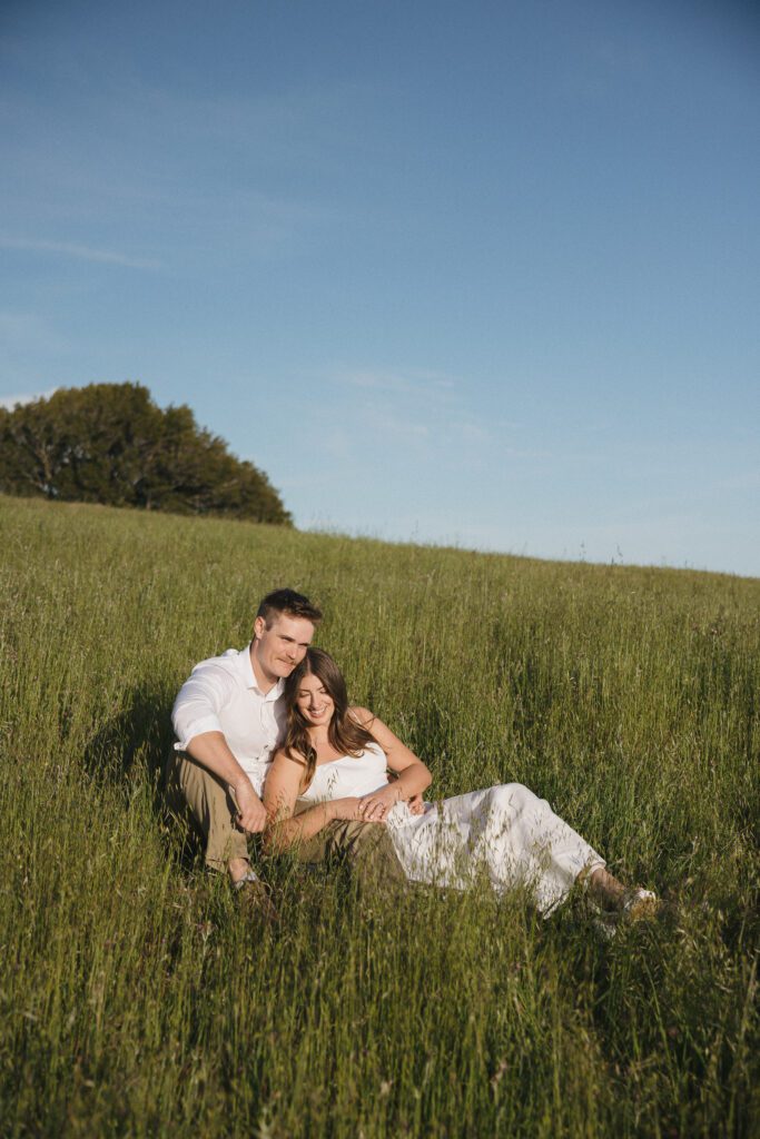Bride- and groom-to-be laughing together during their engagement session.