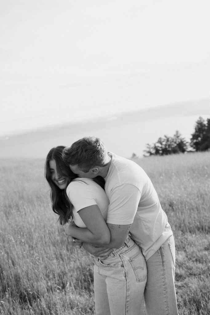 Couple laugh together while taking engagement photos at Mount Tamalpais.