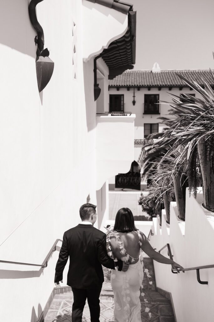 Bride and groom walking through santa barbara courthouse after their wedding ceremony.