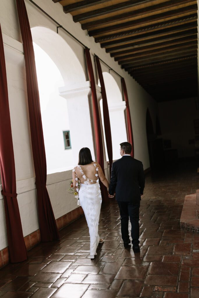 Bride and groom walking through Santa Barbara courthouse after their ceremony.