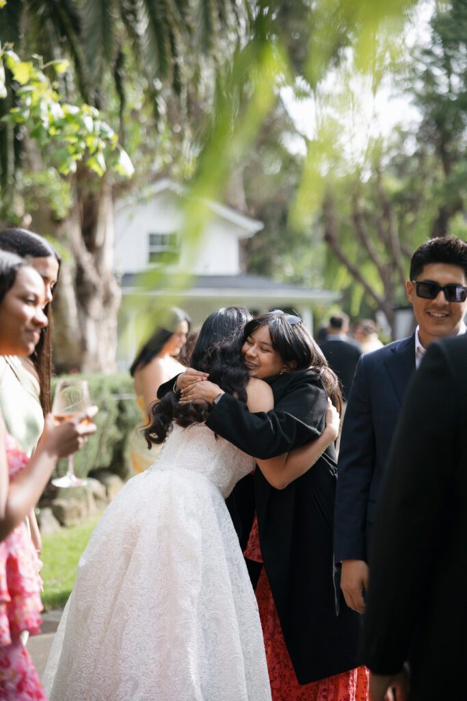 Bride embraces guests during cocktail hour at Cline Cellars wedding reception in Sonoma.