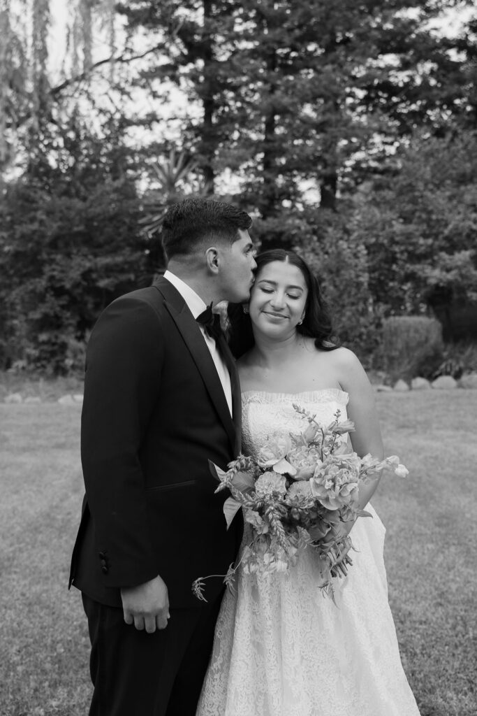 groom candidly kisses bride during golden hour portraits at wedding in Sonoma, California.