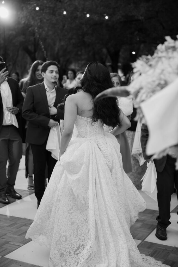 Bride and guests dance together during wedding reception.
